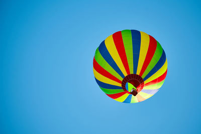 Low angle view of hot air balloon against clear blue sky