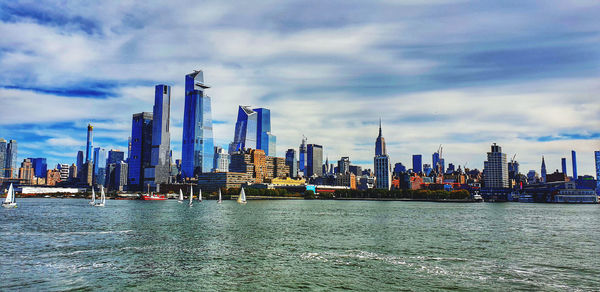 Panoramic view of buildings against cloudy sky