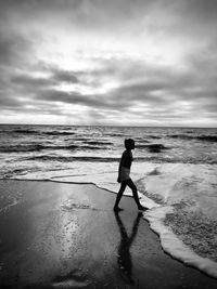 Full length of woman on beach against sky