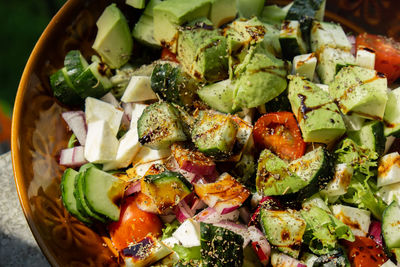Avocado mix of vegetables salad in daytime outdoors. fresh salad with tomatoes, avocado, lettuce