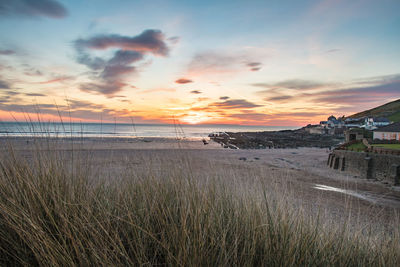 Scenic view of beach against sky during sunset