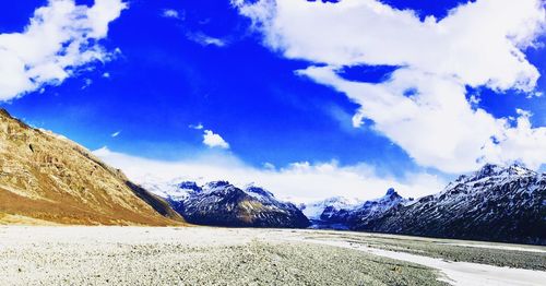 Scenic view of snowcapped mountains against blue sky