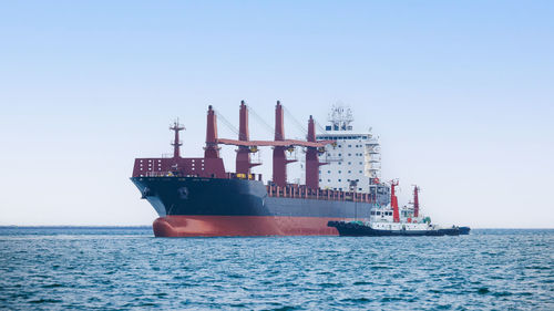 Boats in sea against clear sky
