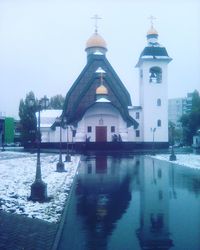 Reflection of church in water against sky