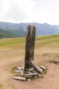 Wood on field by mountains against sky