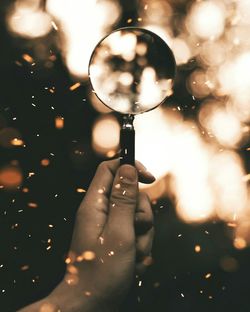 Cropped hand holding magnifying glass
