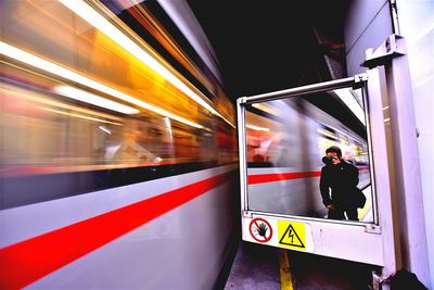 Man taking selfie on subway station platform