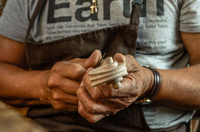 Violin maker luthier hand working a new violin scroll