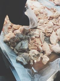 Cropped image of vendor with chicken meat in market