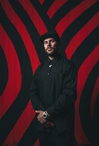 Portrait of man standing against patterned wall