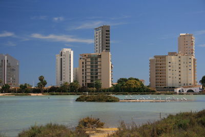 Buildings by city against sky