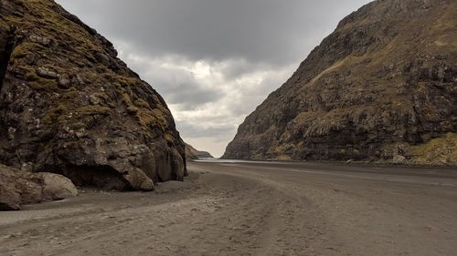 Road amidst rocks against sky