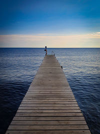 Pier over sea against sky during sunset