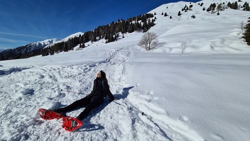 Rear view of person on snowcapped mountains during winter