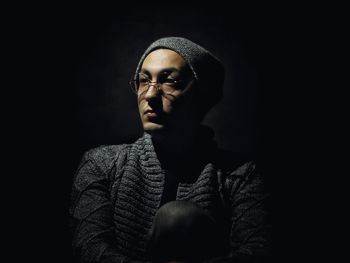 Portrait of young man against black background