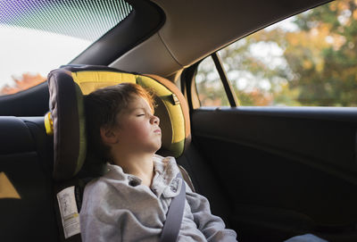 Tired boy sleeping in car