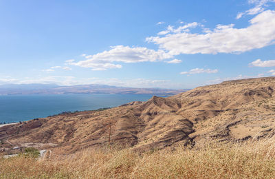 Scenic view of sea and mountains against sky