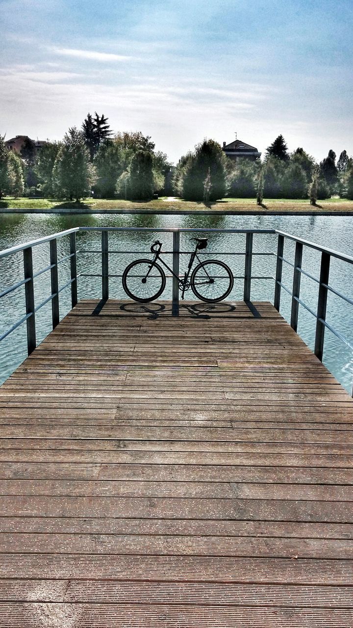 water, railing, lake, pier, tranquility, tranquil scene, wood - material, sky, river, scenics, nature, the way forward, tree, beauty in nature, boardwalk, sunlight, rippled, bridge - man made structure, jetty, footbridge