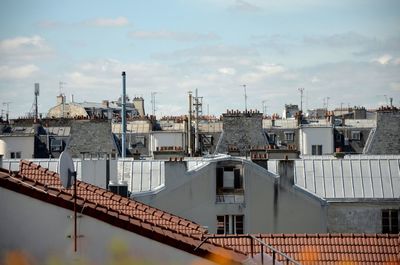 Houses in town against cloudy sky