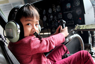 Portrait of boy sitting in cockpit