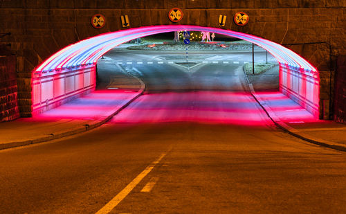 Colorful illuminated tunnel and road at night
