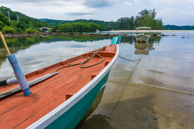 Boats moored on lake against sky