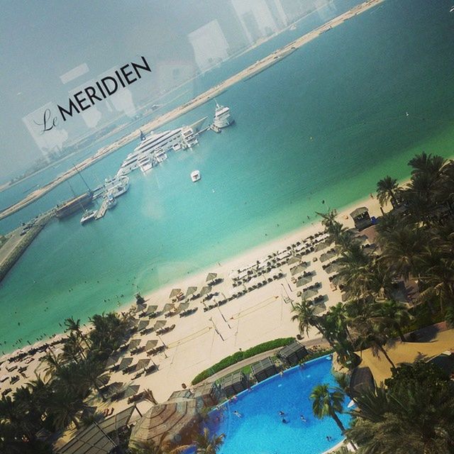 water, sea, beach, horizon over water, high angle view, blue, shore, swimming pool, built structure, nature, coastline, tree, turquoise colored, sky, architecture, sand, day, tranquility, building exterior, outdoors