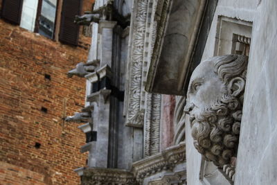 Low angle view of male sculpture on cathedral wall