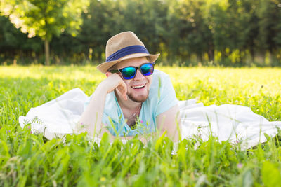 Young man wearing sunglasses lying down on land