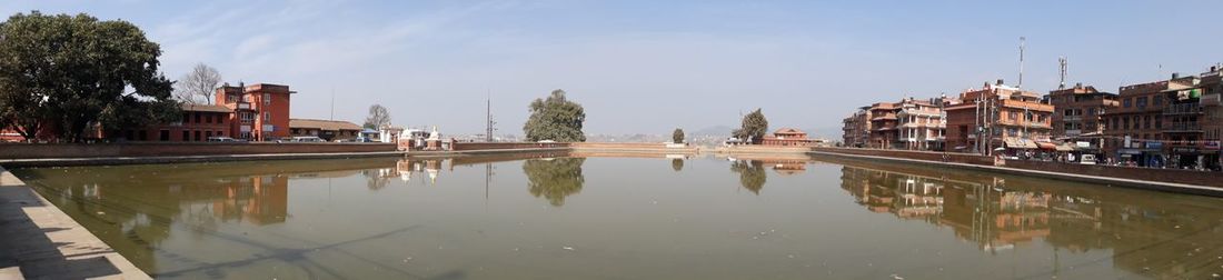 Panoramic view of lake and buildings against sky