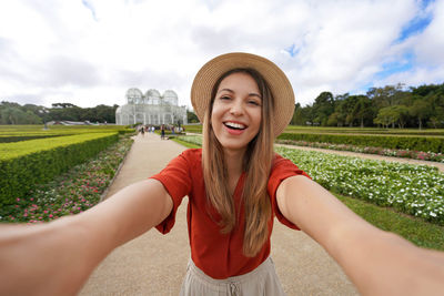 Beautiful smiling girl takes self portrait in the botanical garden of curitiba, parana, brazil