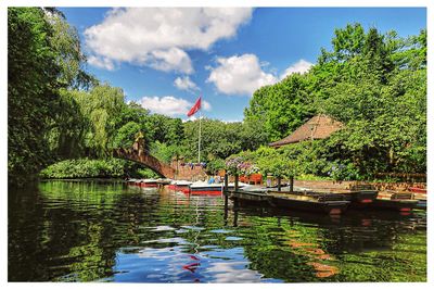 Boats moored at lake against sky