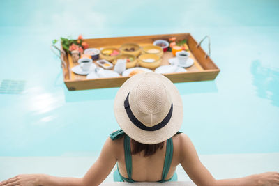 Midsection of woman relaxing in swimming pool