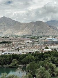 Aerial view of townscape by mountain against sky