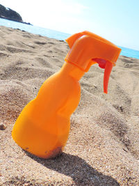 Close-up of orange toy on beach