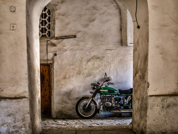 Bicycle parked against building wall