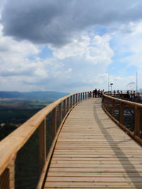 Footbridge over sea against sky