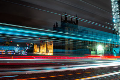 Light trails on city street by buildings at night in london