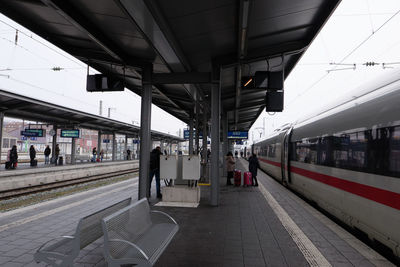 People waiting for a train at the station in cloudy wurzburg.