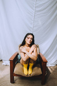 Portrait of young woman sitting at home