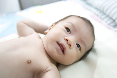 Portrait of cute baby lying on bed