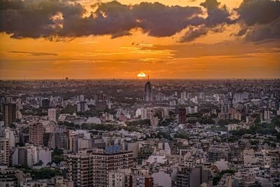 High angle view of city against cloudy sky during sunset