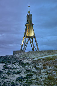 Low angle view of tower on beach against sky