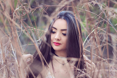 Portrait of young woman amidst grass