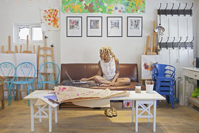 A young woman on a sofa with a laptop