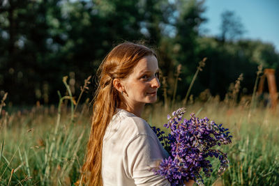 Close up portrait of young beautiful redhead woman with freckles, wearing white dress