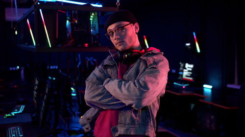 Portrait of young man standing in internet cafe