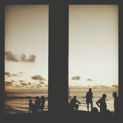 Silhouette of people in sea at sunset