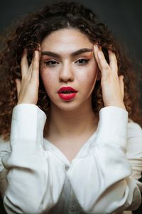 Portrait of young woman against black background