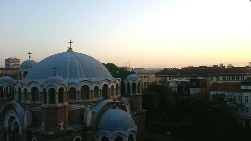 Cathedral in city against clear sky at sunset